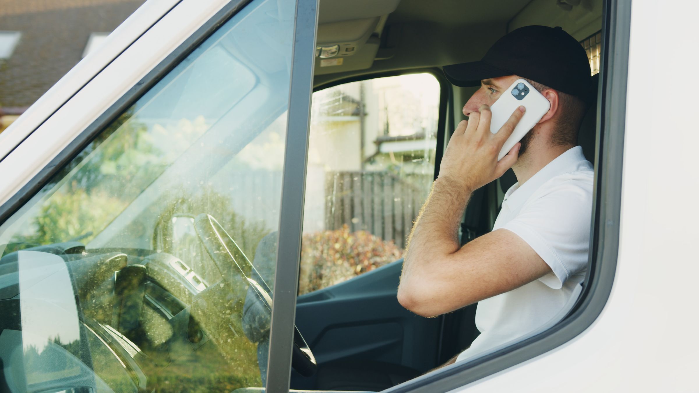 Handwerker telefoniert mit dem Smartphone im Transporter