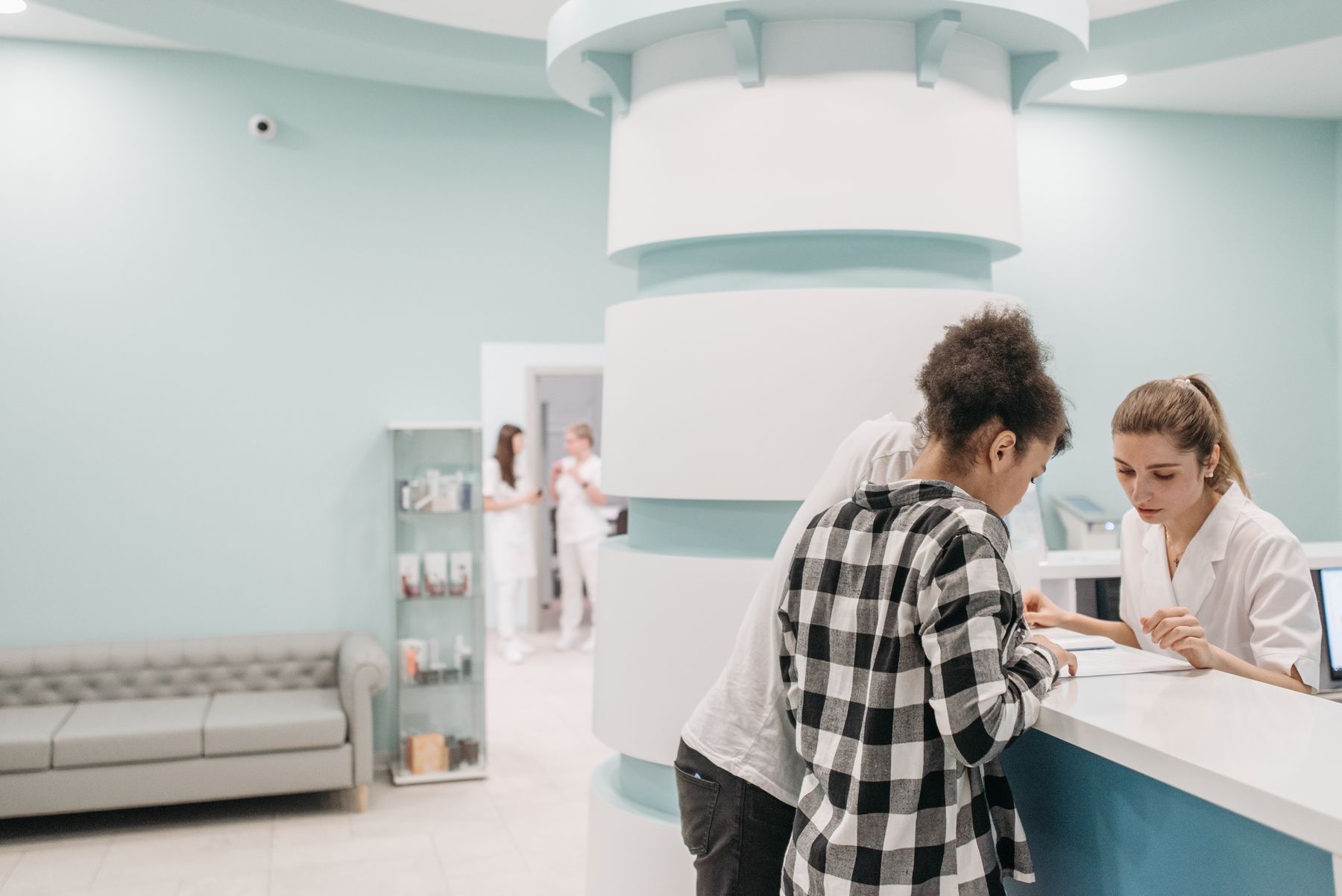 Patientin im Gespräch am Empfang einer Praxis